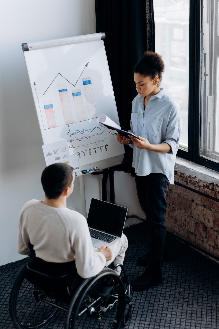 Two colleagues working through market charts together